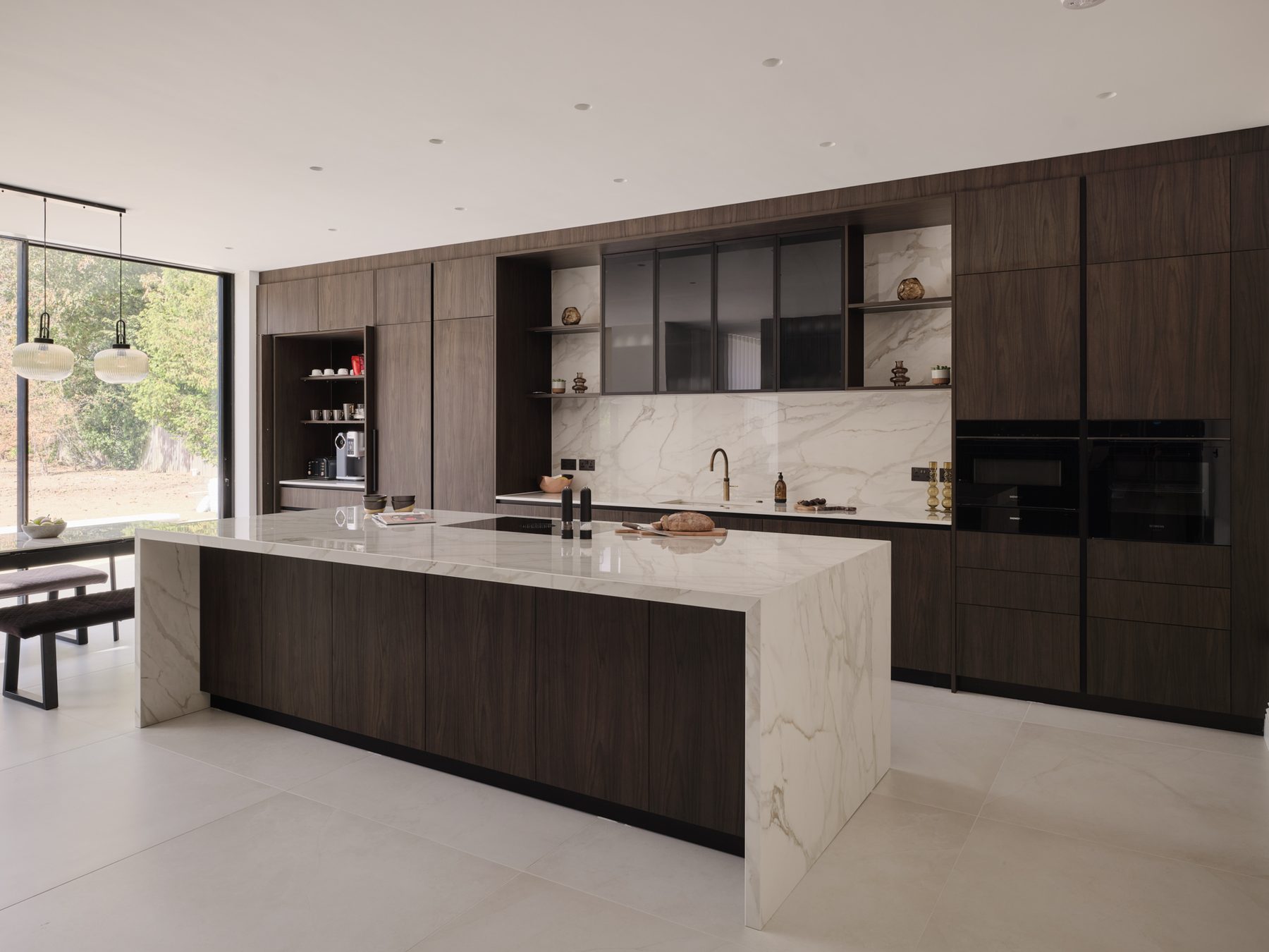 A finished Sheraton kitchen with dark wood-grain tall units and a light veined waterfall island